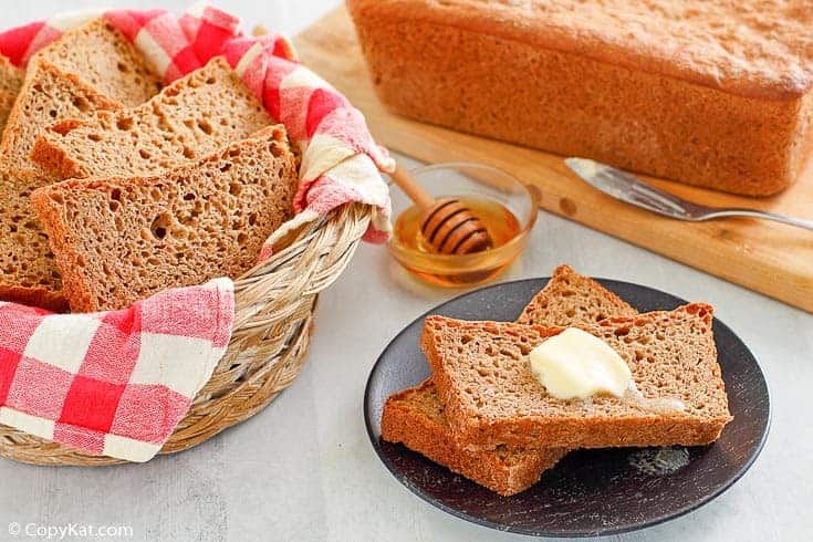 Fluffy whole grain wheat bread loaf cooling on a kitchen rack.