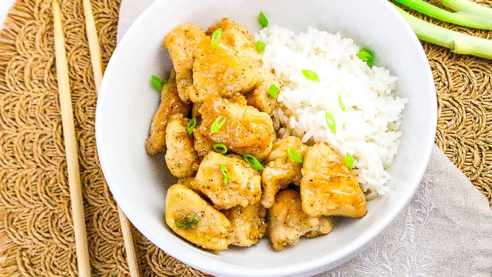Crispy honey butter chicken served with white rice in a white bowl.