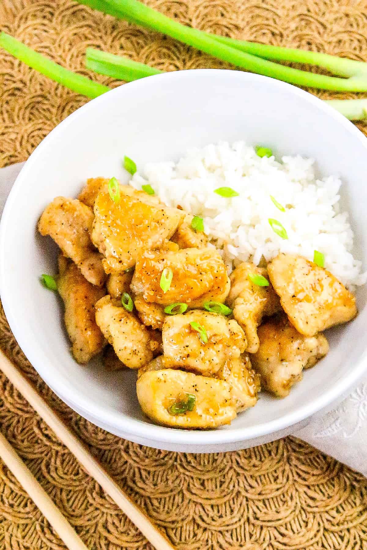 Crispy honey butter chicken served with fluffy white rice in a white bowl.