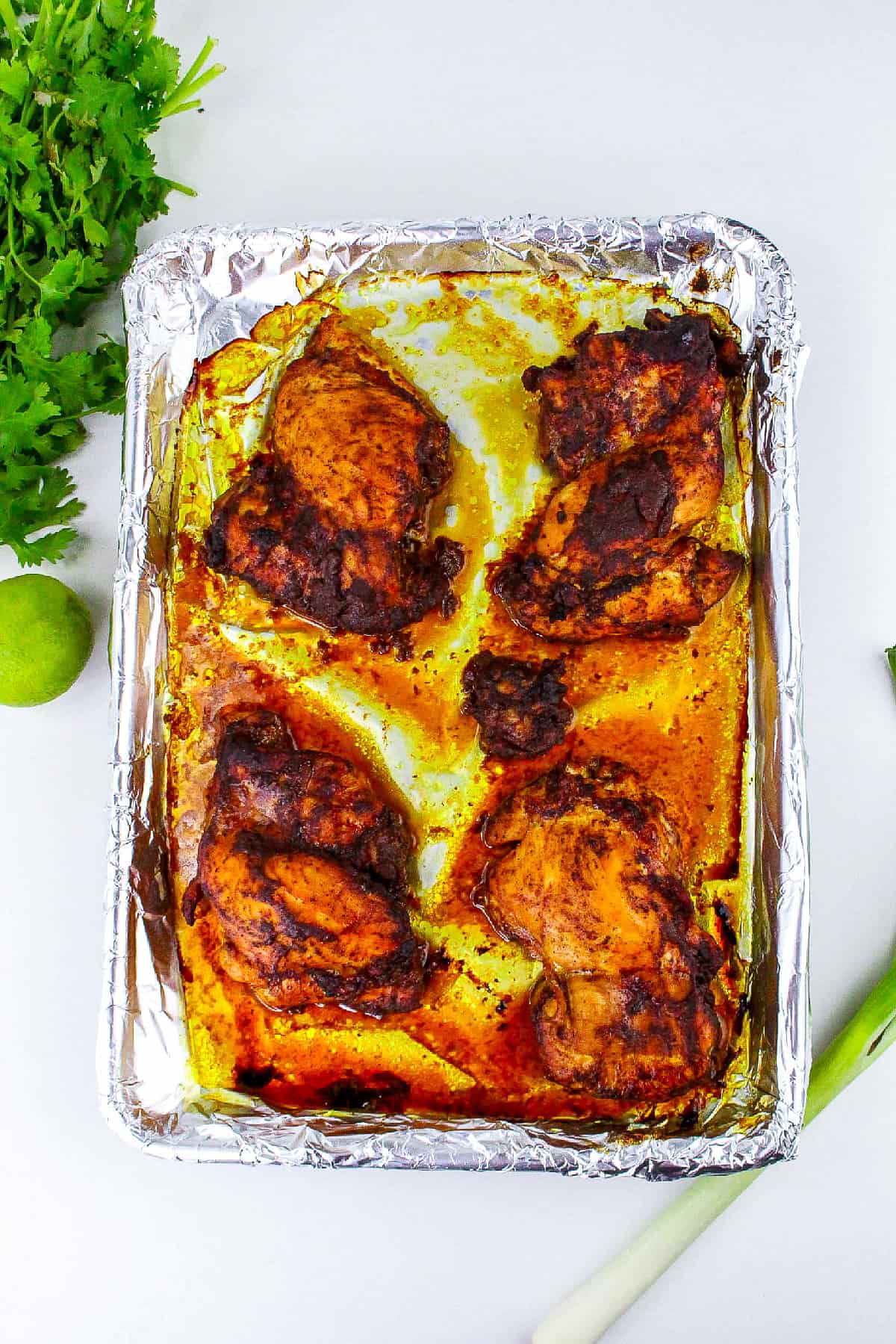 Baked tandoori masala chicken fresh from the oven on foil-lined tray.