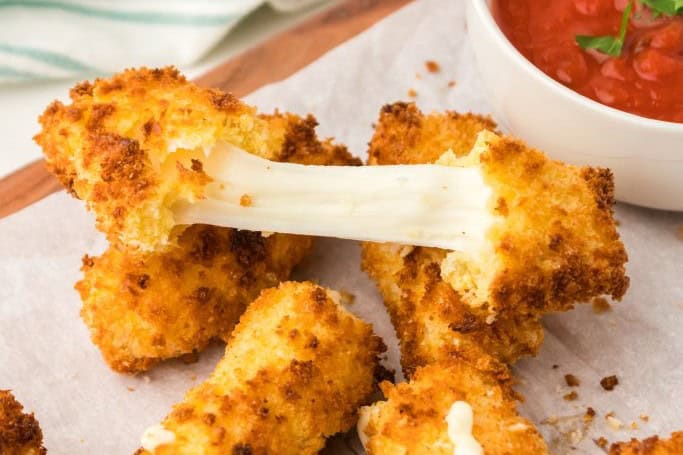 Homemade air fryer mozzarella sticks golden and melty inside.
