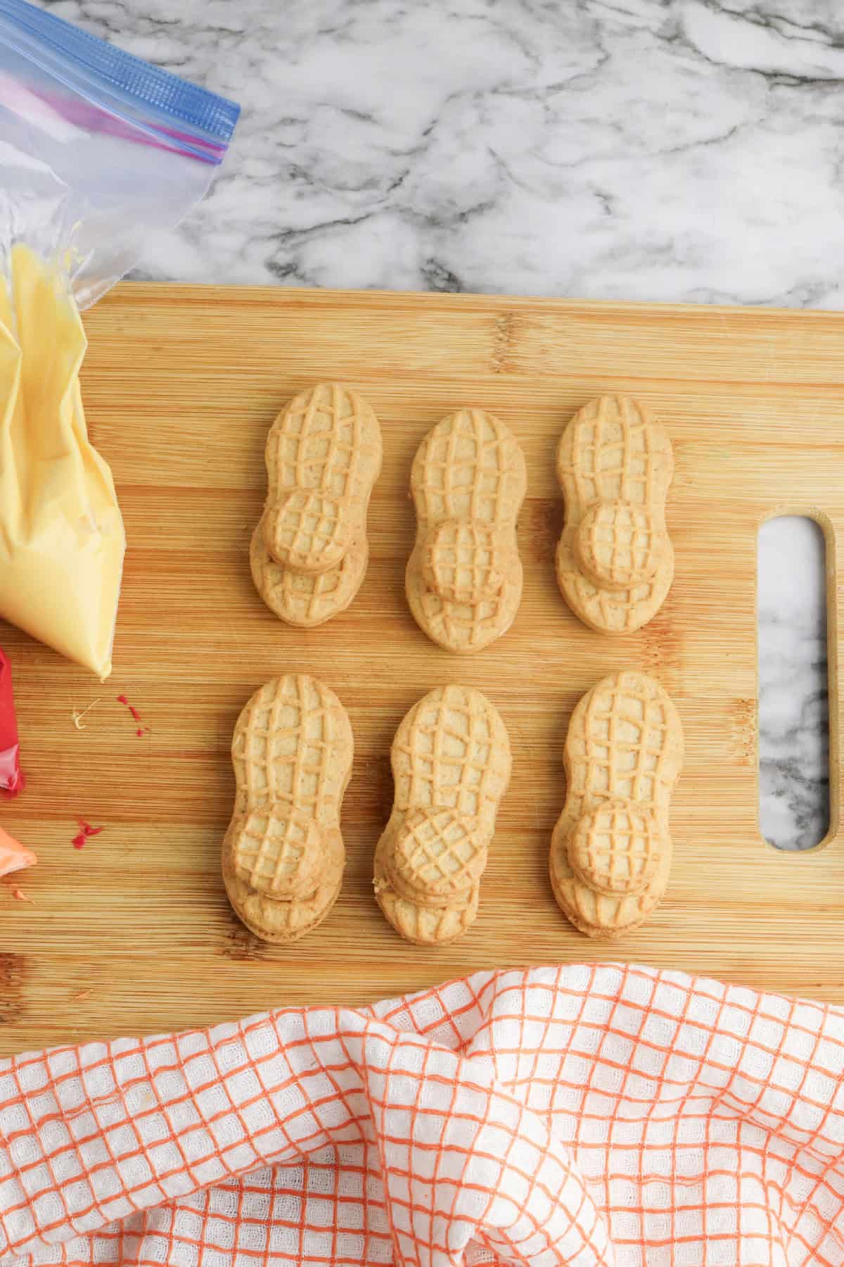 Nutter Butter cookies arranged on a wooden cutting board ready to be decorated for turkey cookies.