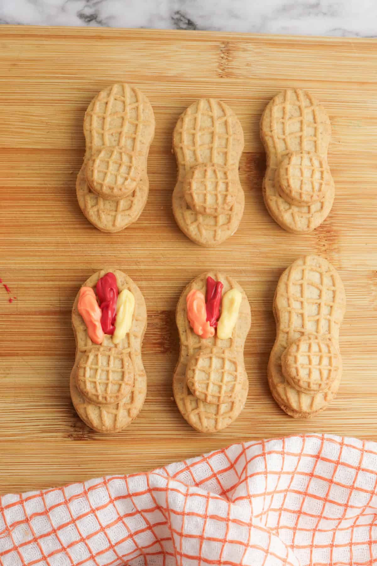 Nutter Butter cookies with red, orange, and yellow icing added on top to create colorful turkey feathers.