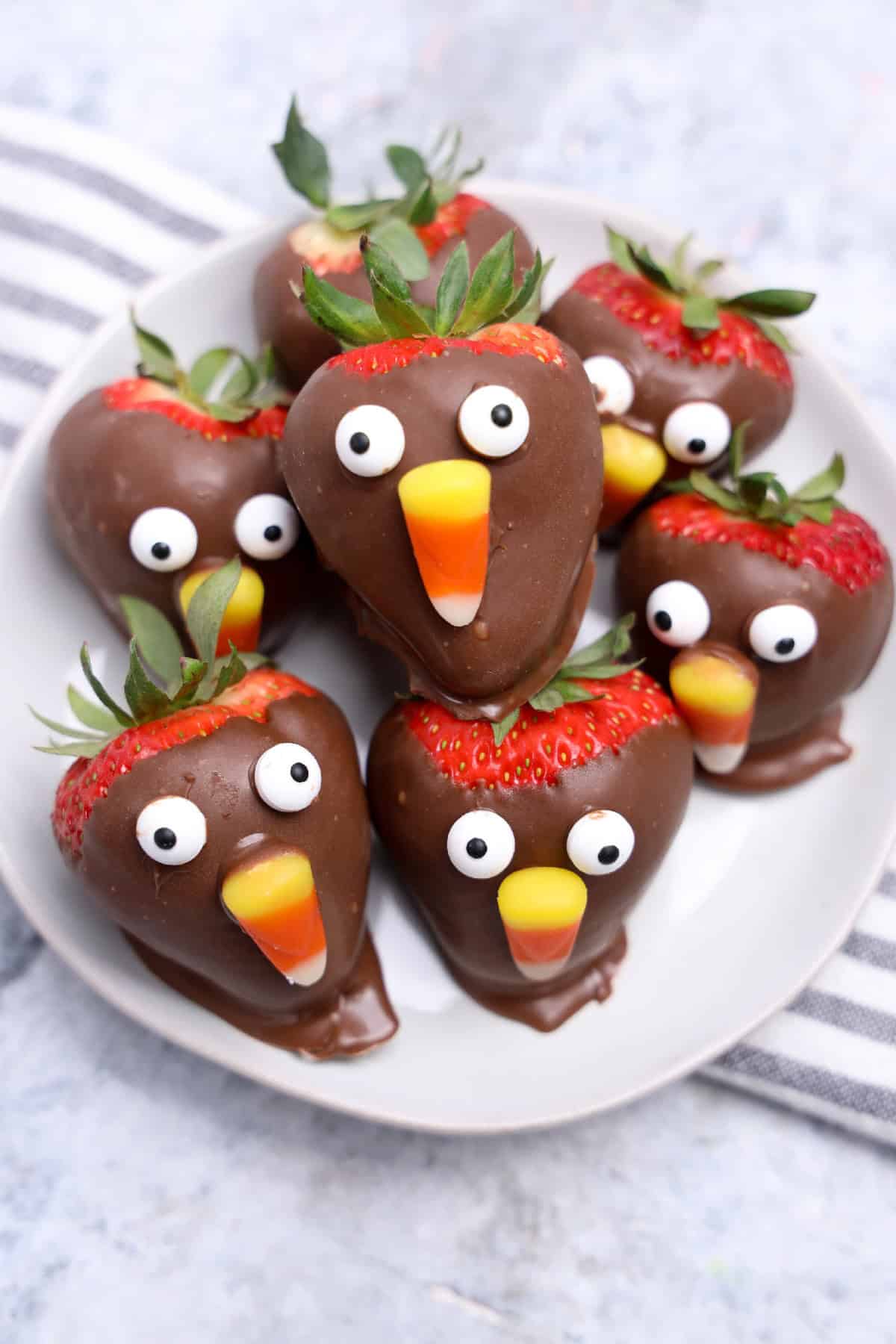 Chocolate-covered strawberries decorated with candy corn beaks and candy eyes to look like Thanksgiving turkeys.