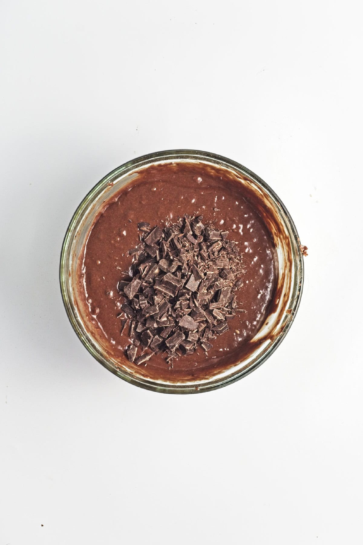 Chopped dark chocolate added on top of chocolate banana batter – mix-ins for vegan chocolate banana bread.