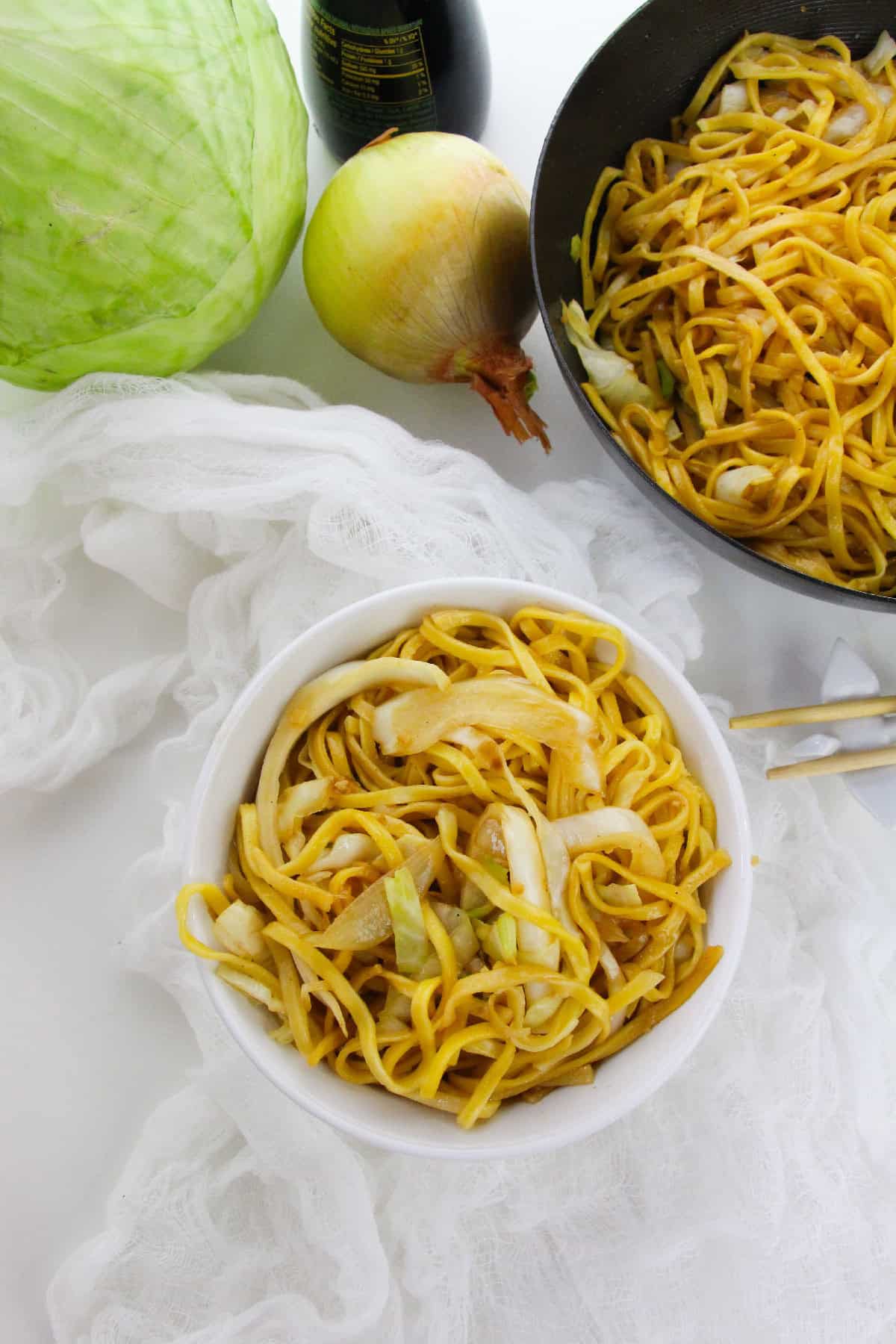 Bowl of homemade vegetarian cabbage chow mein noodles with onions and cabbage.