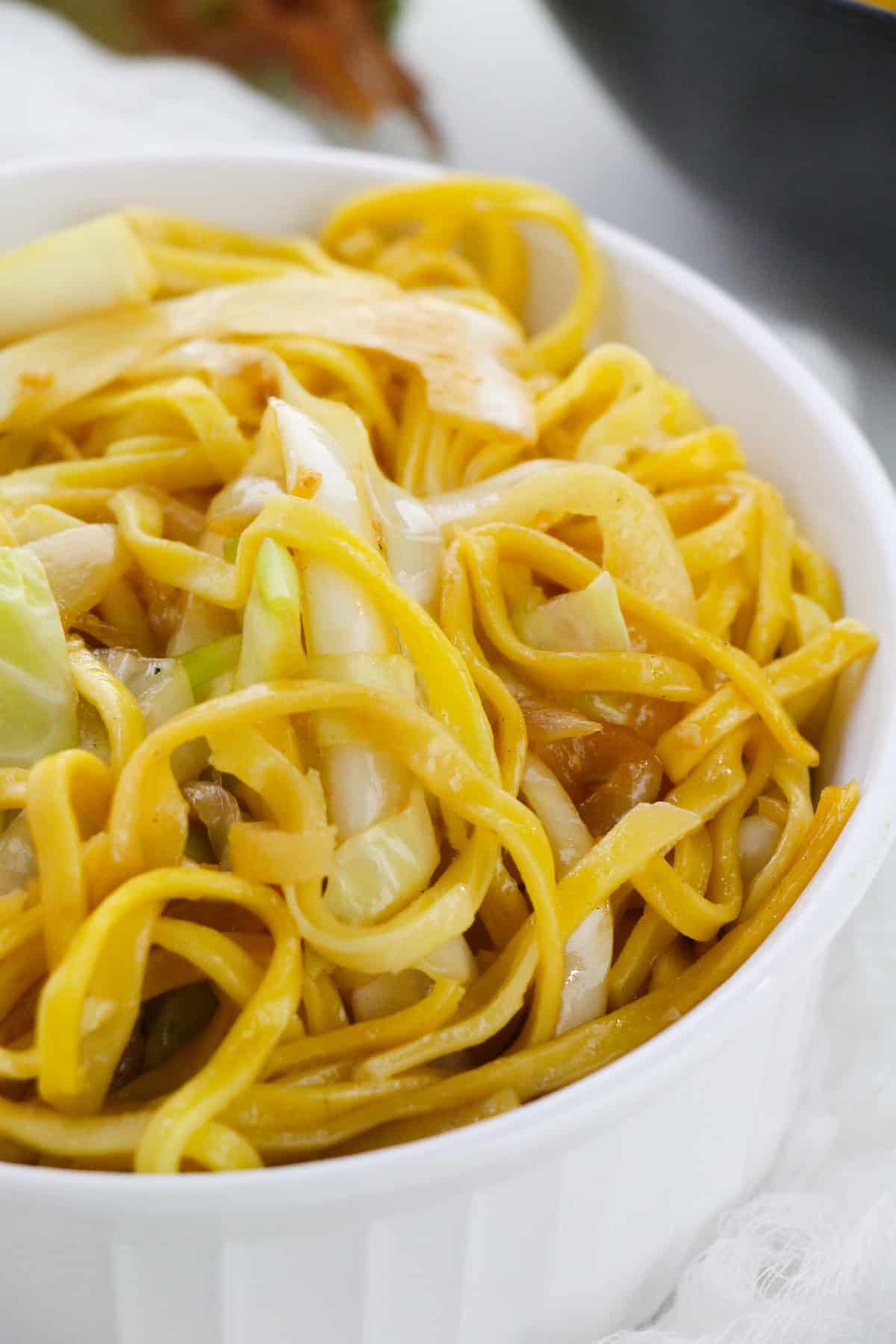 Asian-inspired cabbage noodle stir fry served with chopsticks.