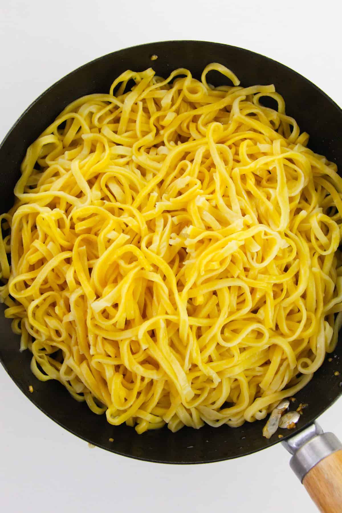 Cooked yellow noodles drained and placed in a wok.