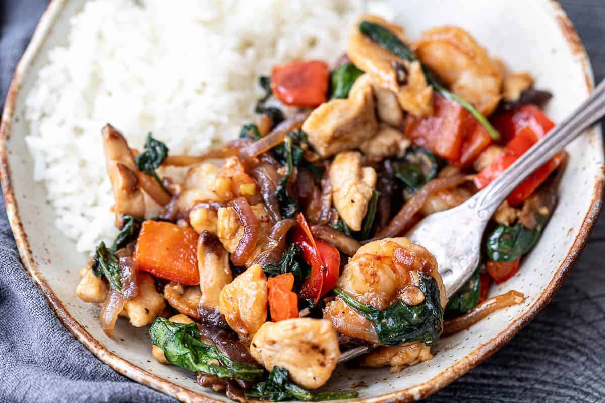 Chicken and shrimp stir fry with vegetables in sauce.