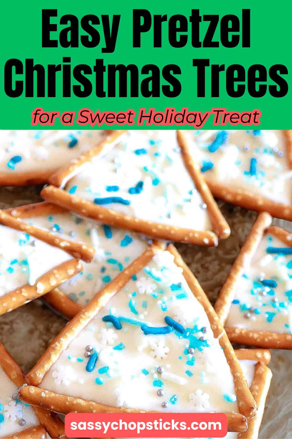 Triangle pretzel Christmas tree cookies decorated with white icing, sprinkles, and snowflake candy on parchment paper.
