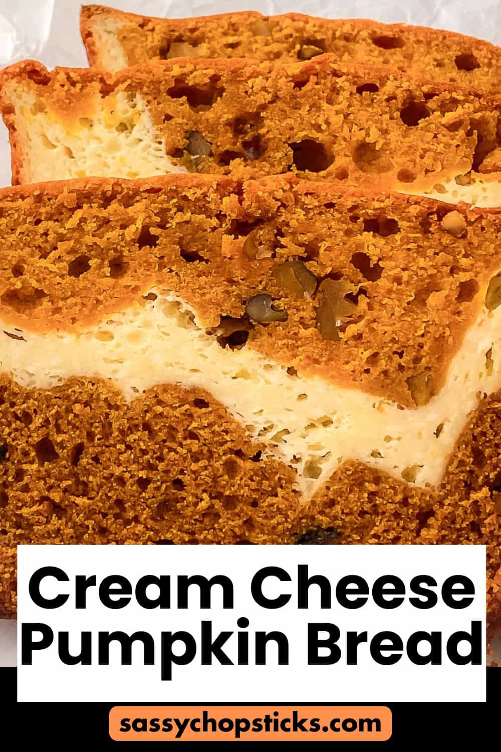 Close-up of moist cream cheese pumpkin bread slices showing a rich orange pumpkin layer swirled with creamy cheesecake filling.