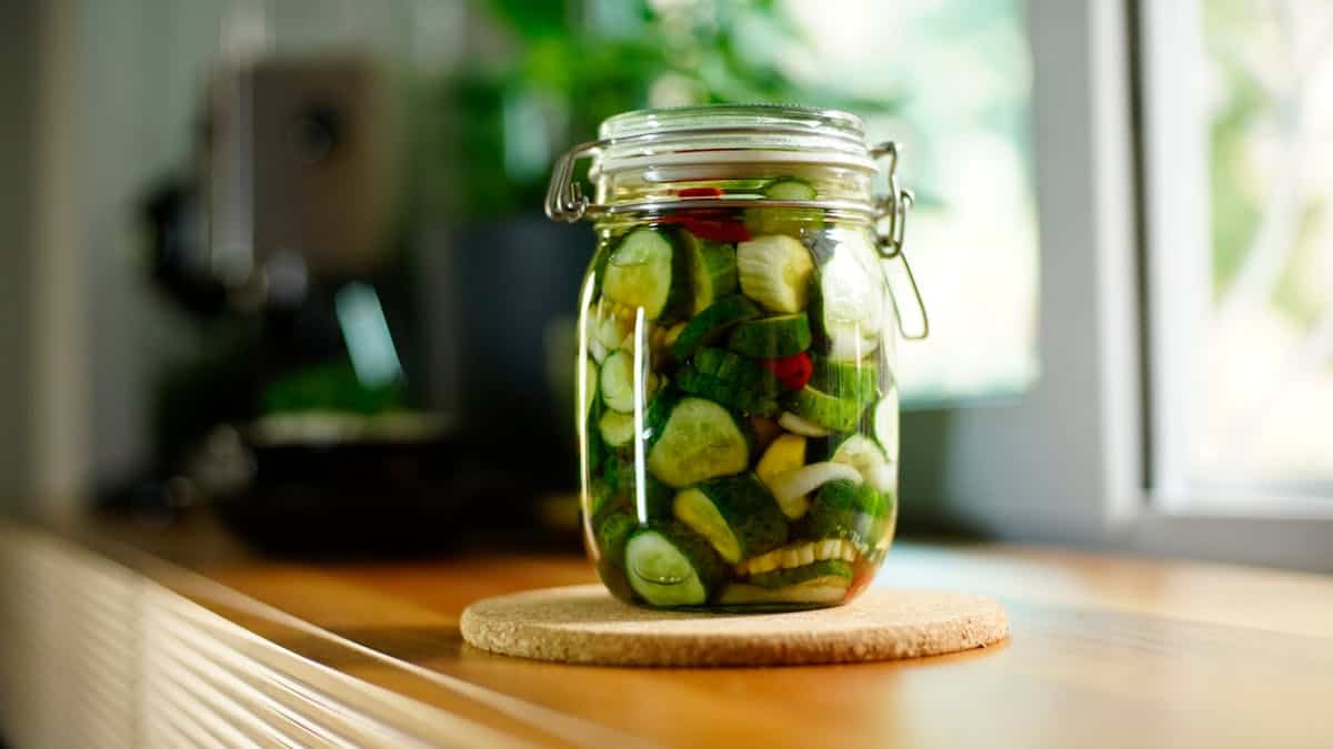 Fermented vegetable pickles in glass jar, Veggie Chopsticks, healthy snack, vegan, probiotic-rich fermented vegetables, kitchen decor.