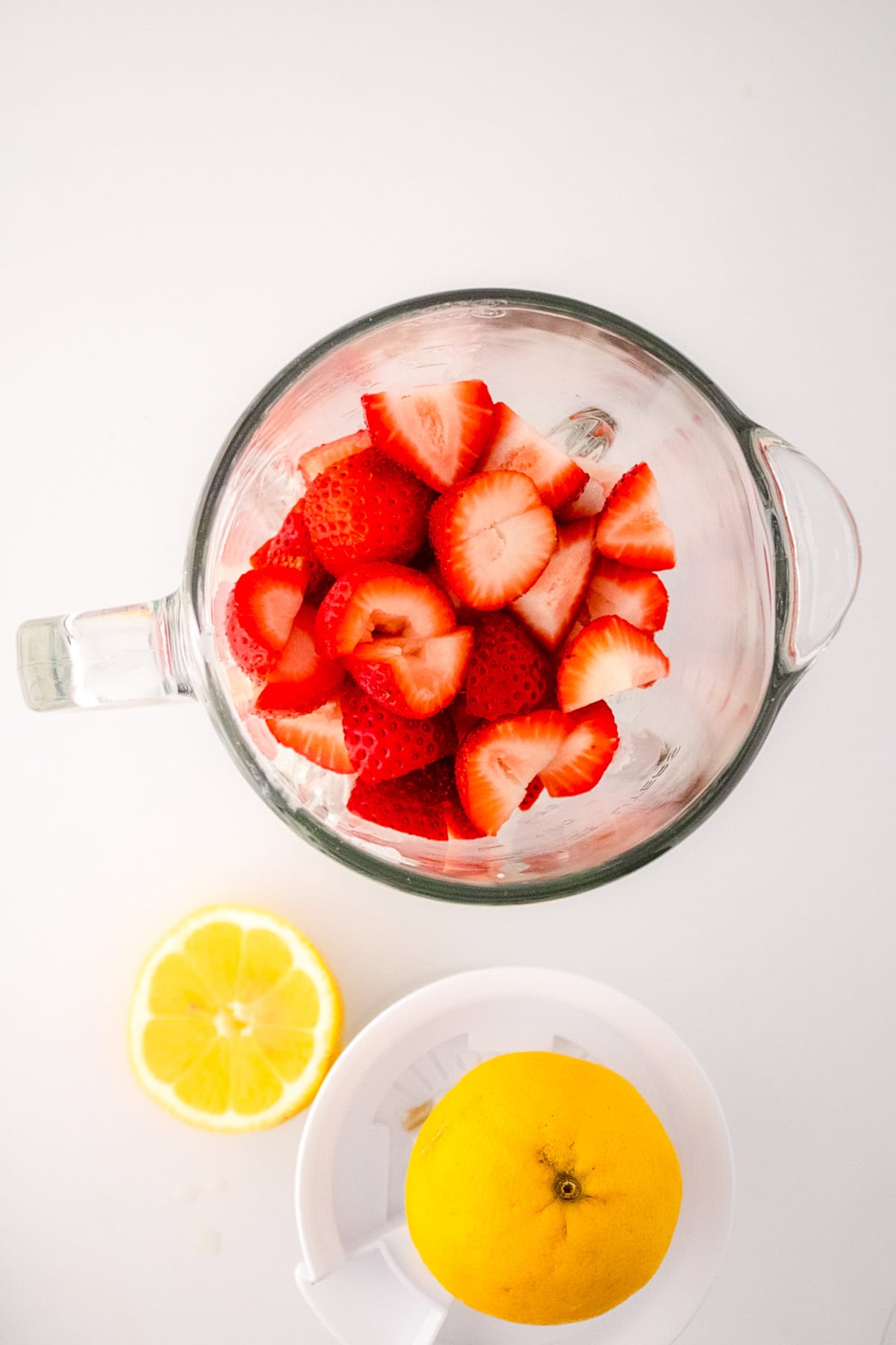 Fresh strawberries and lemon ready to blend for vegan strawberry ice cream.