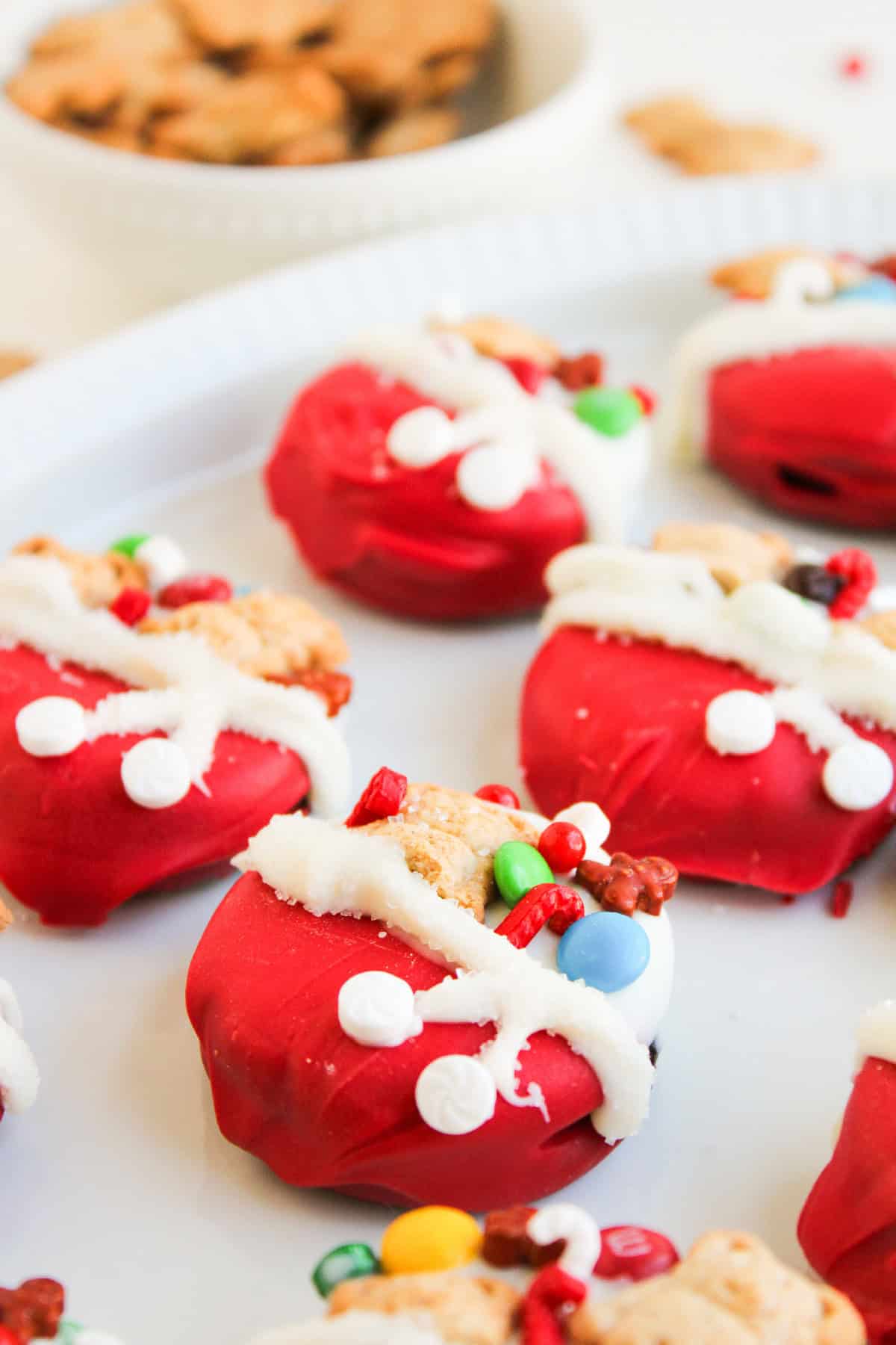 Close-up shot highlighting the textured red candy coating and festive toppings on a Christmas Oreo cookie.