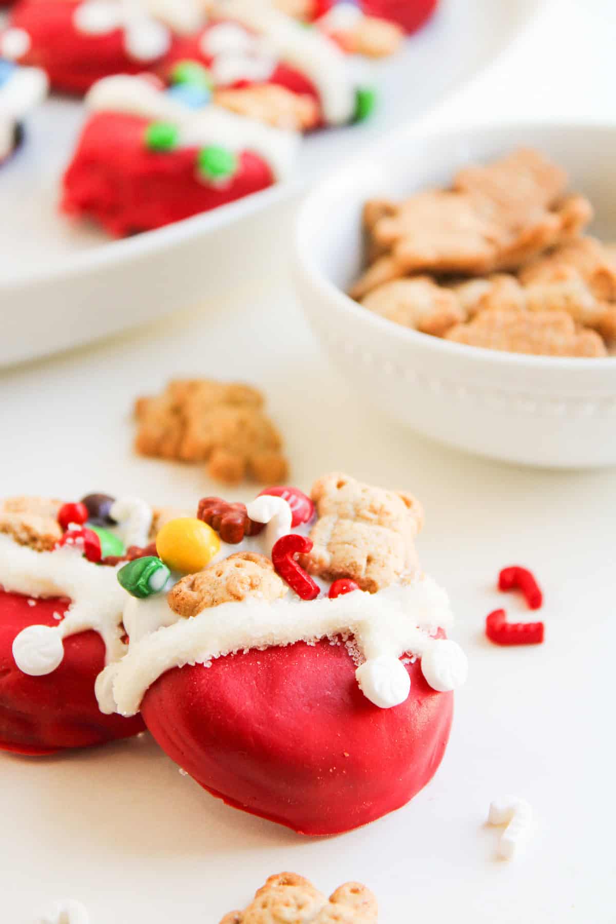 Bright overhead shot of decorated Christmas Oreos styled as Santa toy bags, filled with red, green, and blue candies.