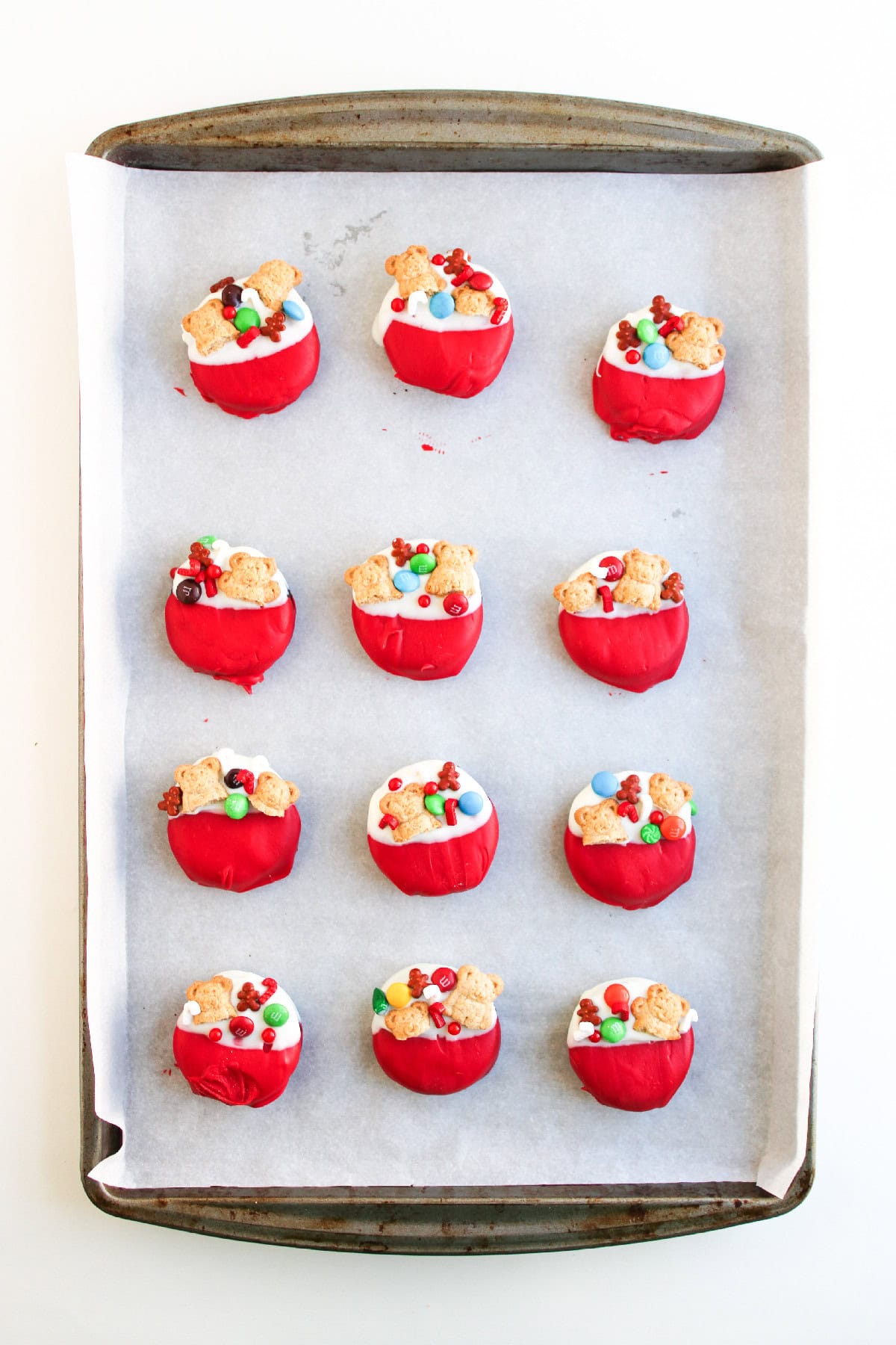 A tray filled with decorated red and white cookies that look like festive Christmas stockings.