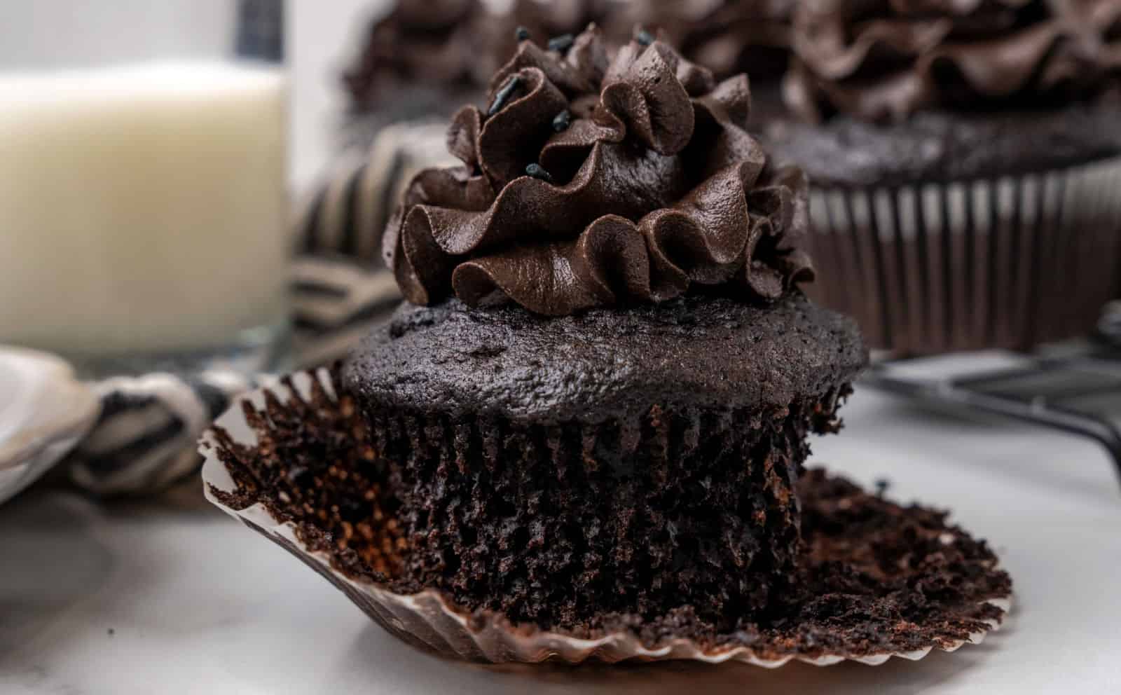 A group of black cupcakes decorated with black frosting.