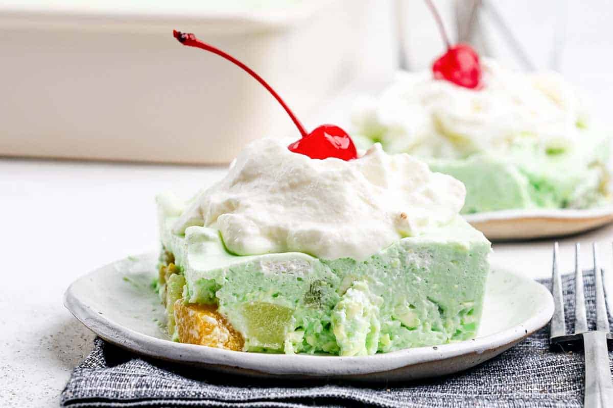 Retro lime Jell-O salad with whipped topping and fruit.