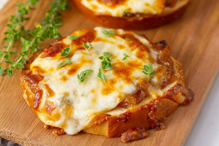 Toasted baguette slices topped with caramelized onions and melted cheese.