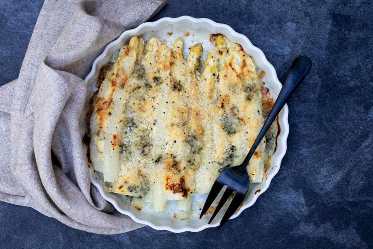 White asparagus gratin topped with creamy Roquefort cheese.