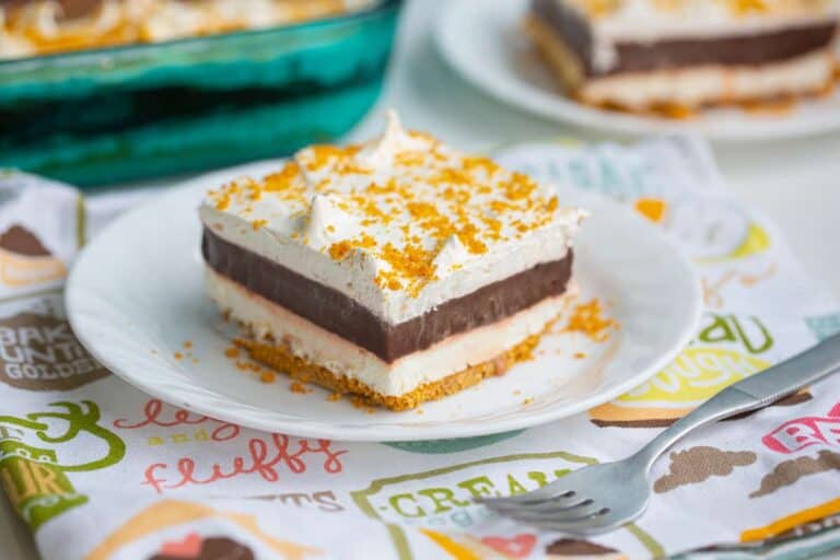 Layered chocolate dessert with pudding, whipped cream, and cookie crust.