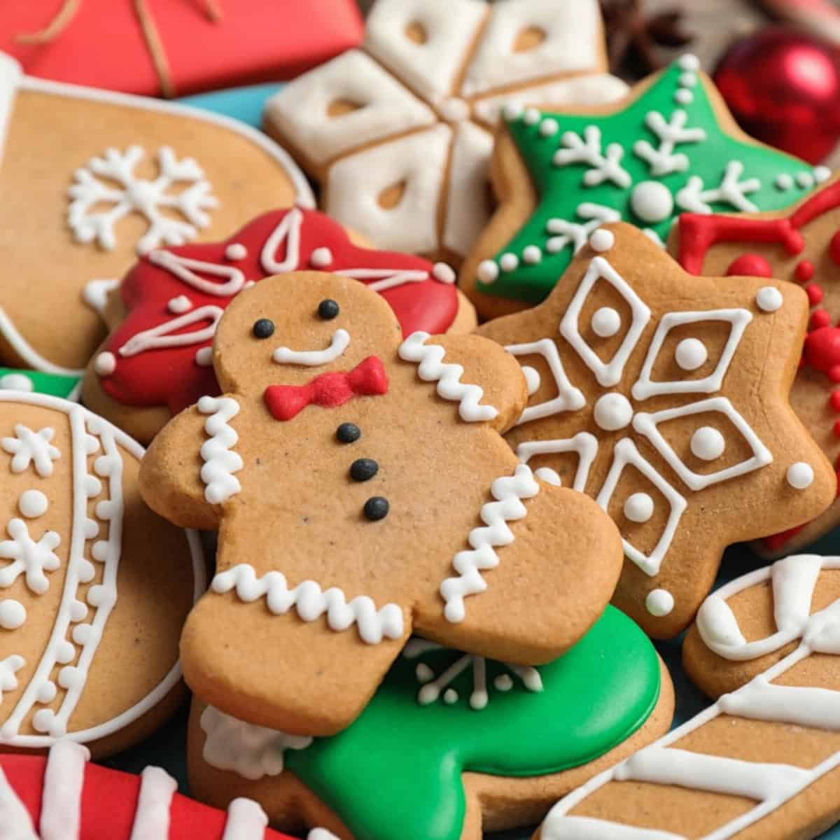 Assorted festive Christmas cookies decorated with colorful icing, including gingerbread men, snowflakes, stars, and candy cane shapes.
