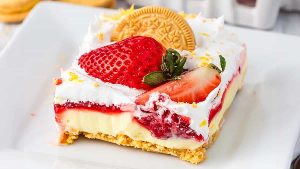 A layered dessert with lemon cheesecake and strawberries.
