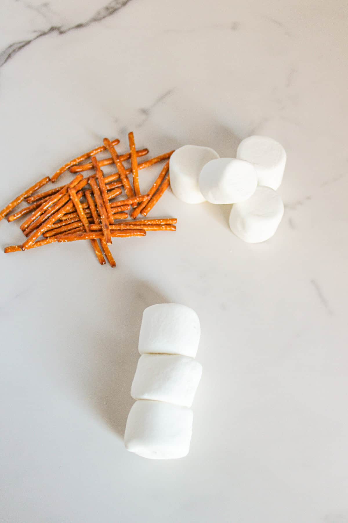 Three marshmallows stacked on top of each other to form the body of a snowman.