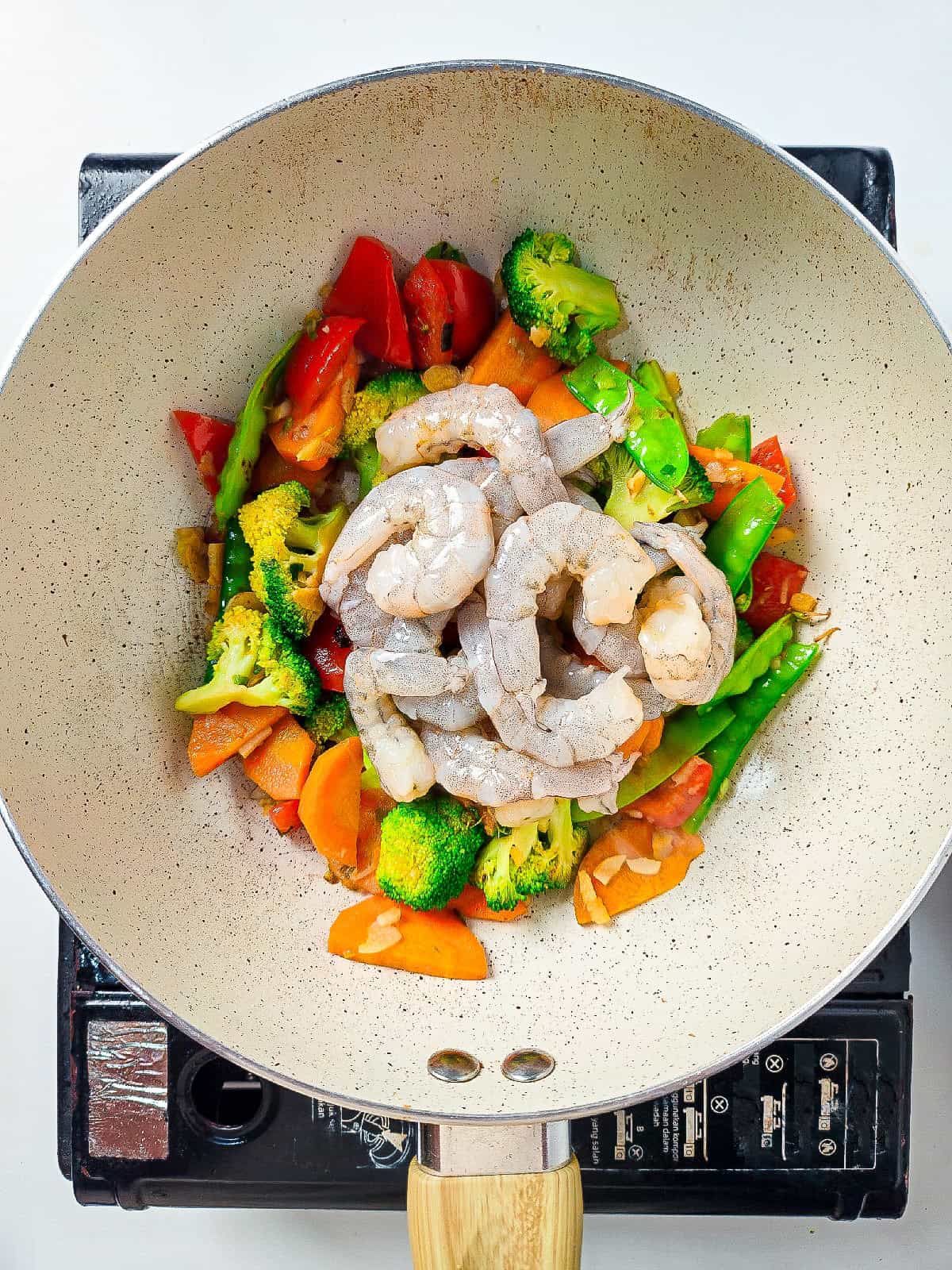 Colorful vegetables sautéing in a wok for shrimp and vegetable stir fry.