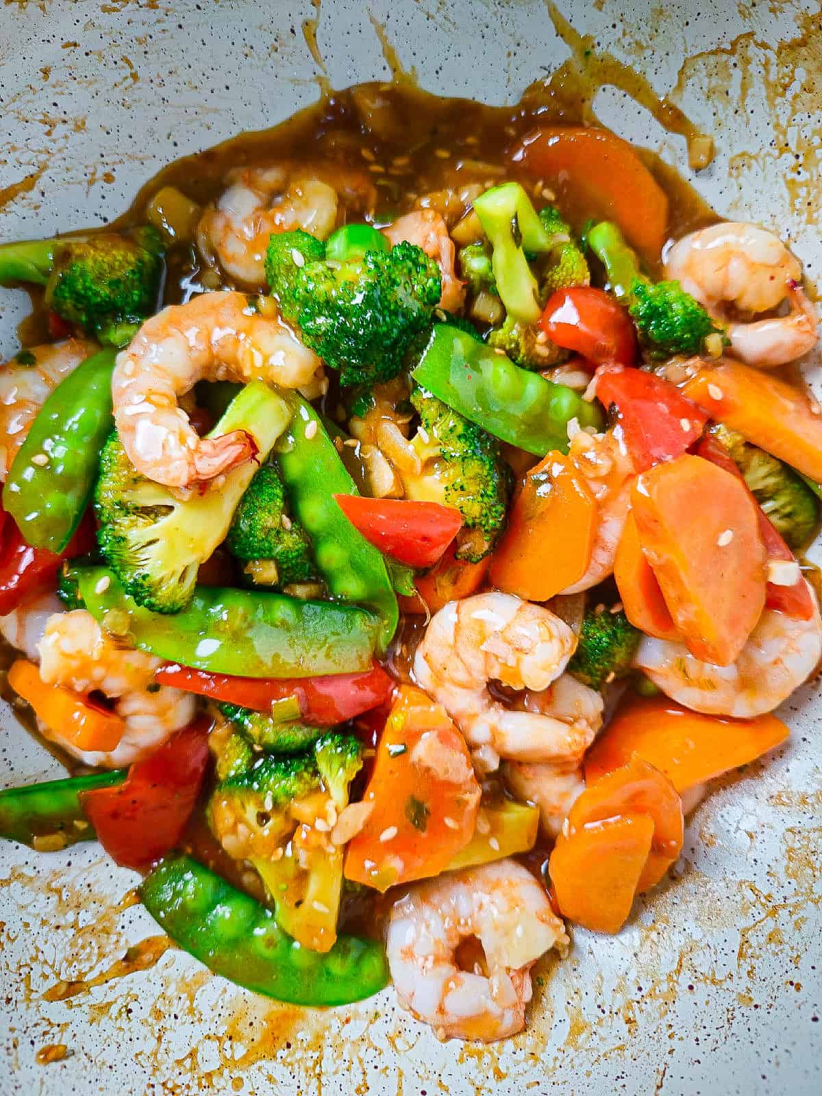 Finished shrimp and vegetable stir fry coated in sesame soy sauce, ready to serve.
