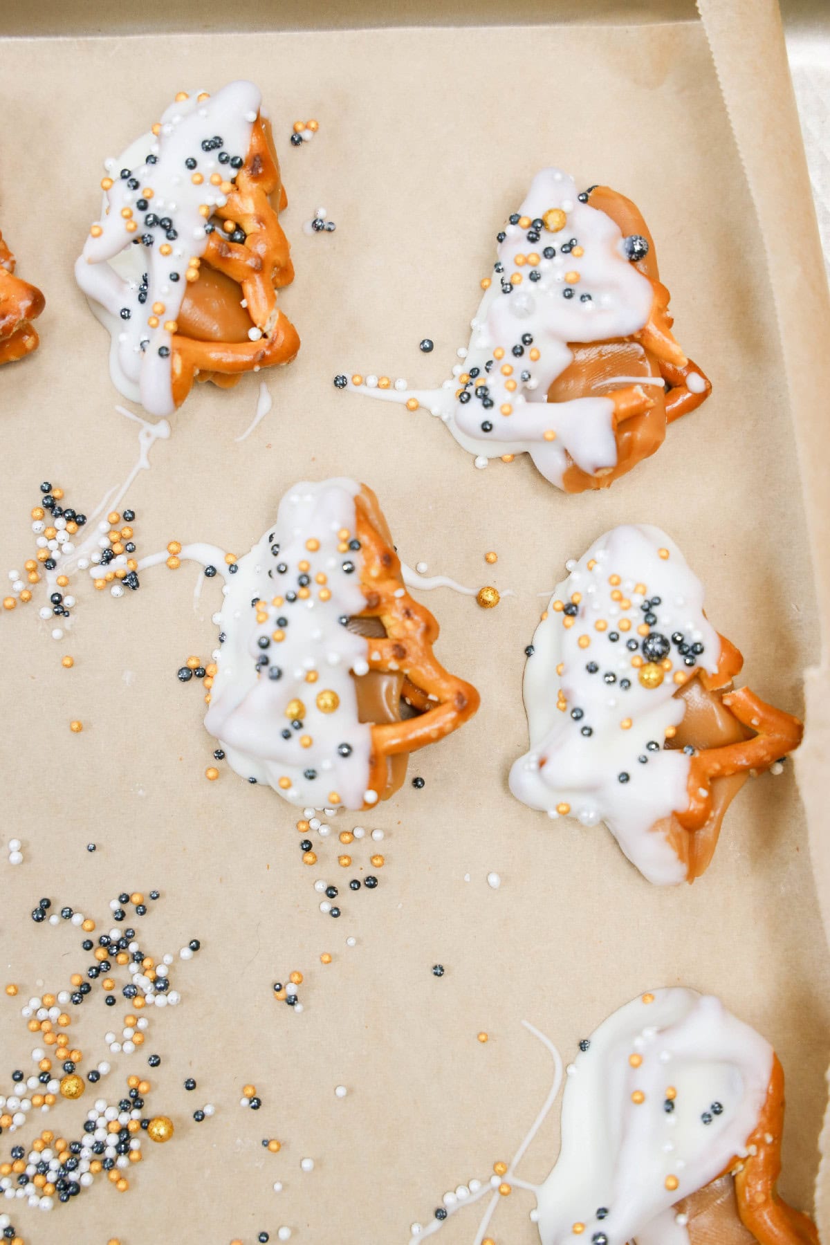 Caramel pretzels dipped in white chocolate and decorated with festive sprinkles.