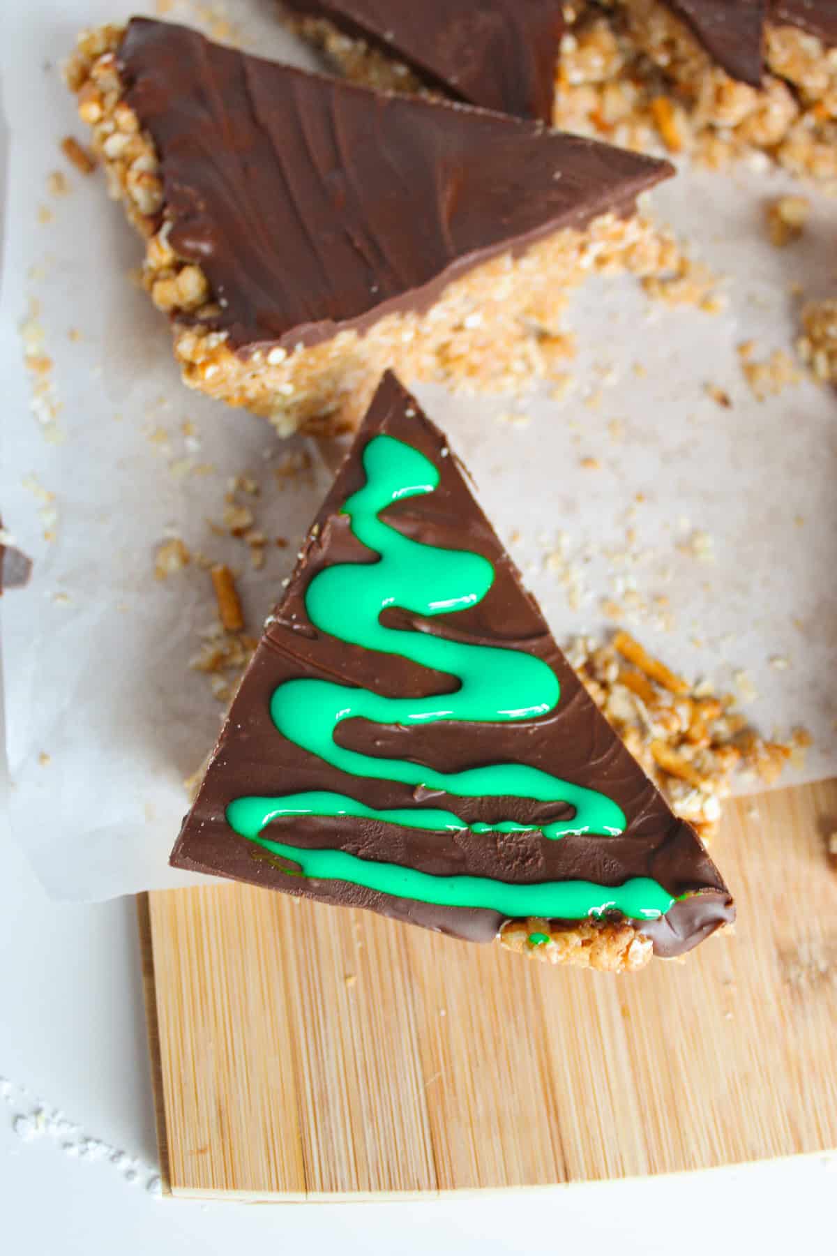 A chocolate peanut butter Christmas tree bar decorated with green icing.