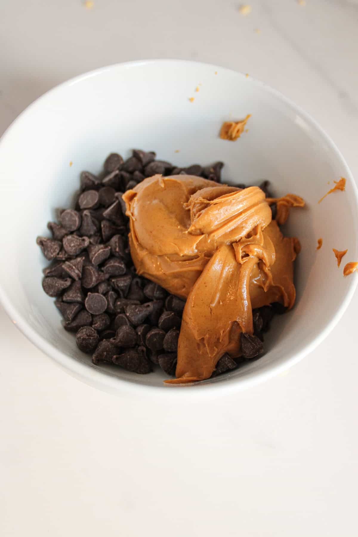 Chocolate chips and peanut butter added together in a bowl before melting.