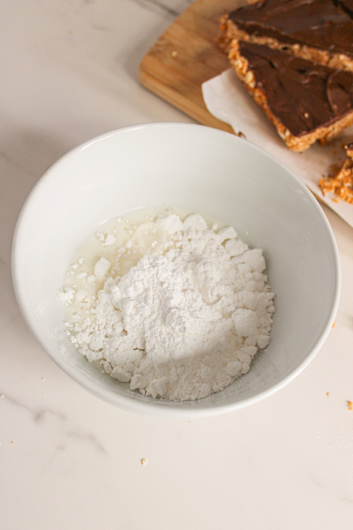 Powdered sugar and milk in a bowl to make icing.