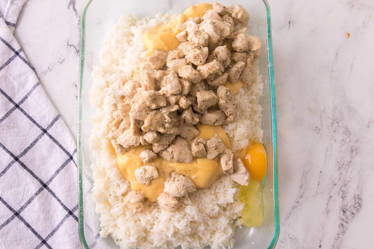 Cooked chicken added on top of the creamy rice mixture for baked chicken broccoli rice casserole.