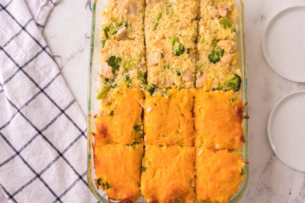 Golden brown cheesy chicken broccoli rice casserole baked and cut into squares for serving.
