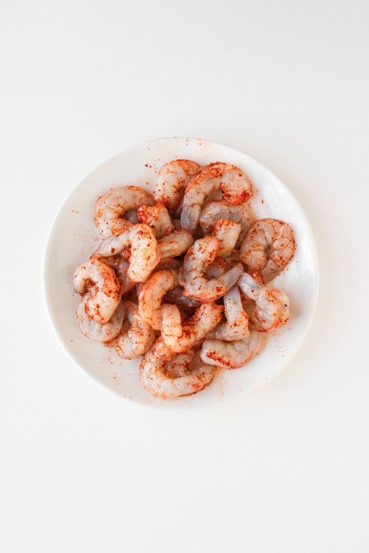 Shrimp being coated in cornstarch before frying.