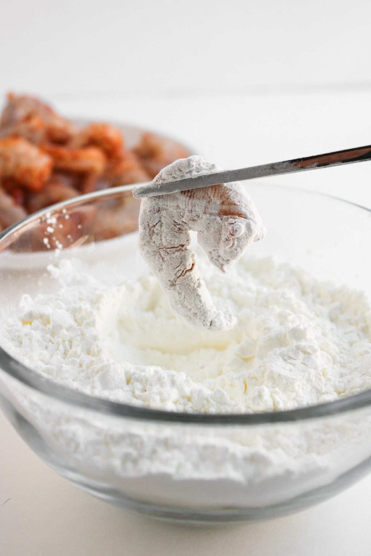 Bang bang sauce ingredients in small bowls on a white surface.