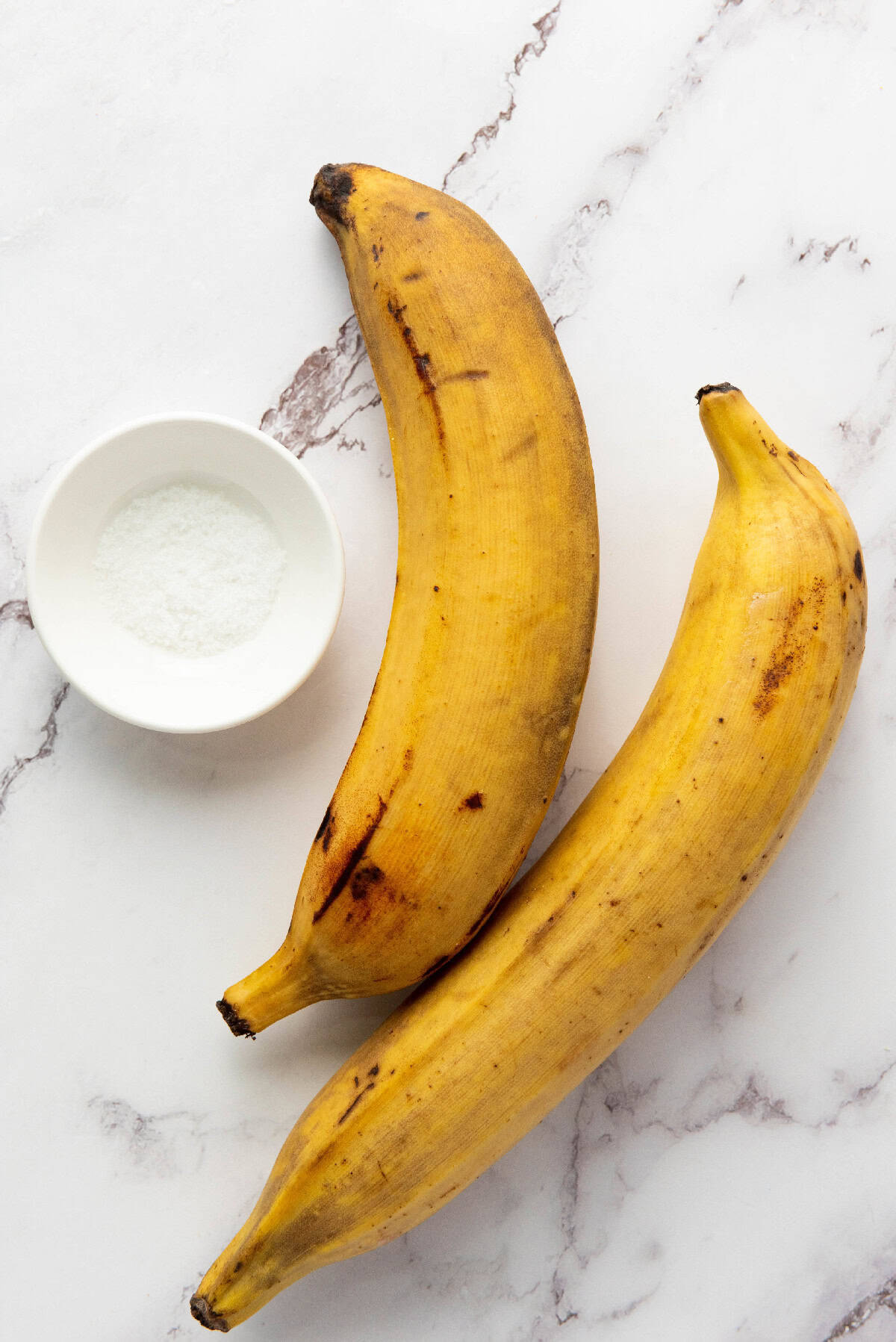 Fresh plantains and salt ready for making homemade chifles.