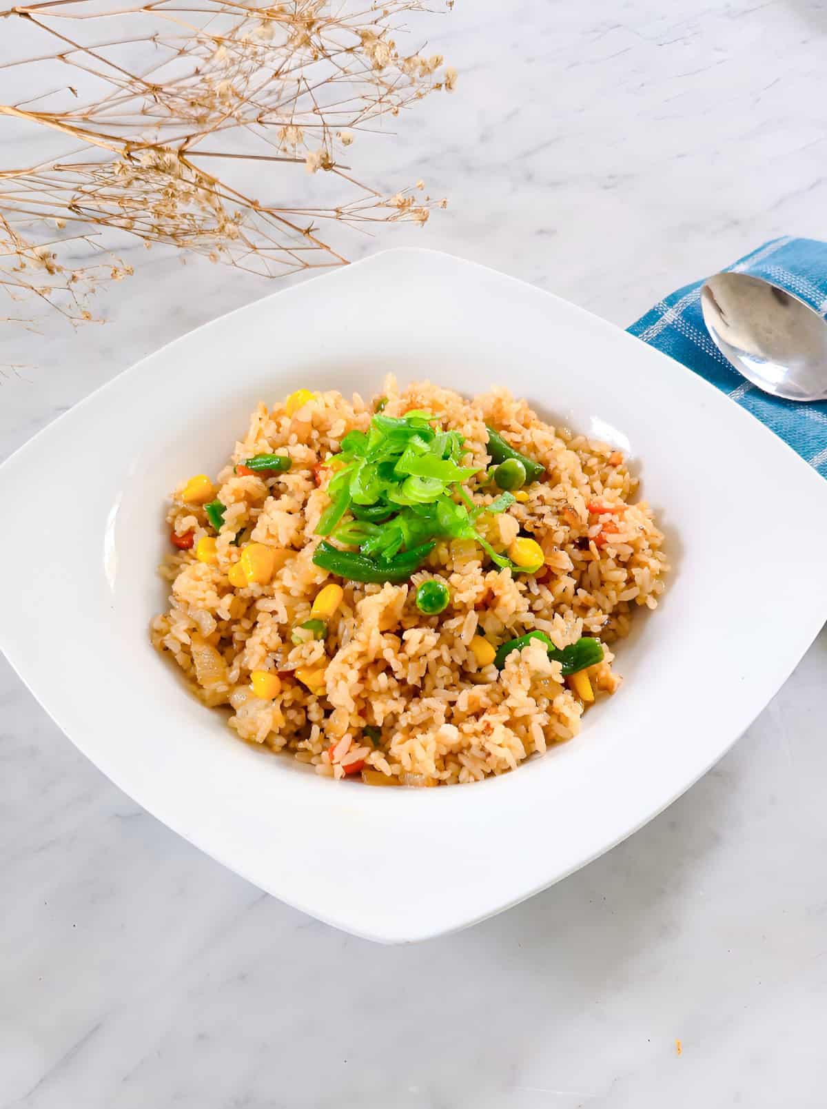 Vegetable fried rice made with frozen mixed vegetables and topped with scallions.