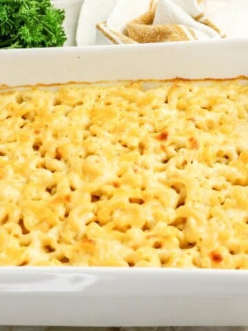 Baked three cheese macaroni and cheese in a white casserole dish.