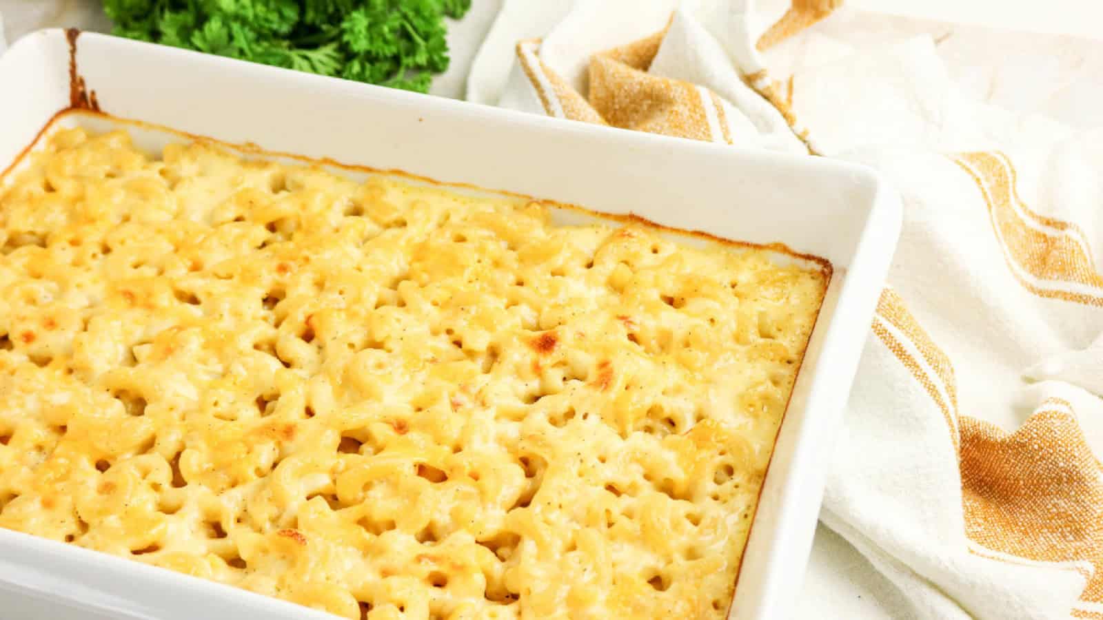 Baked three cheese macaroni and cheese in a white casserole dish.