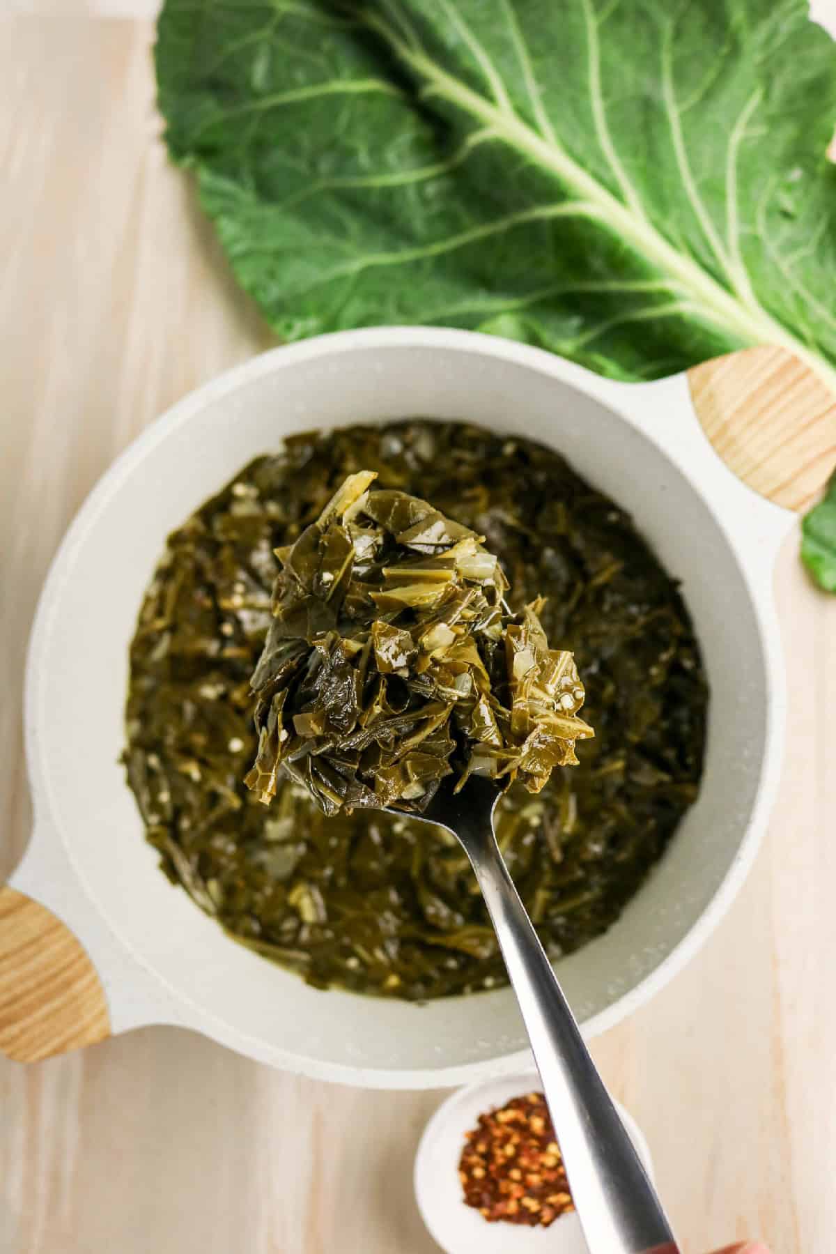 Close-up of braised collard greens showing soft texture and chopped leaves.
