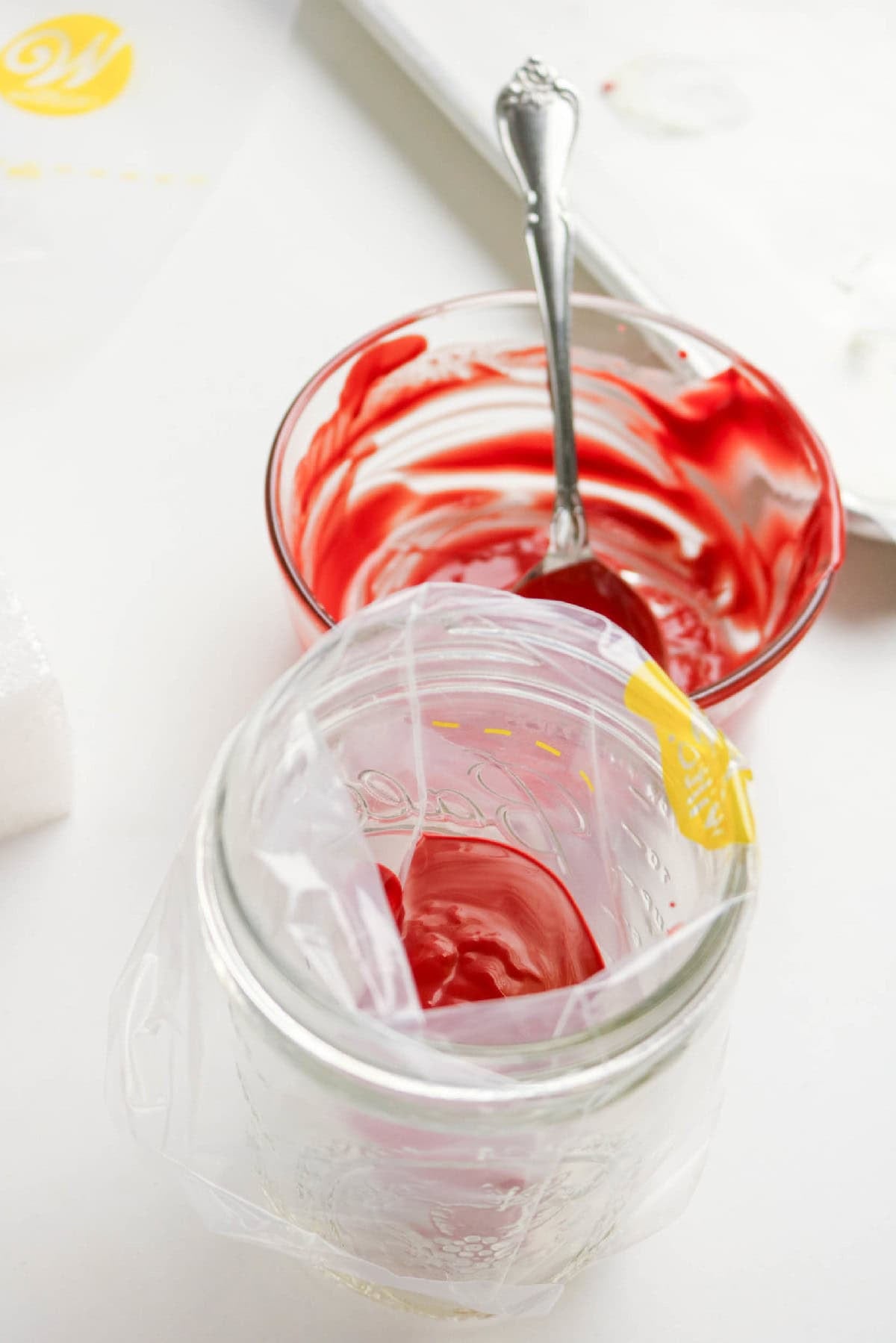 Melted red candy coating prepared in a piping bag for decorating cake pops.