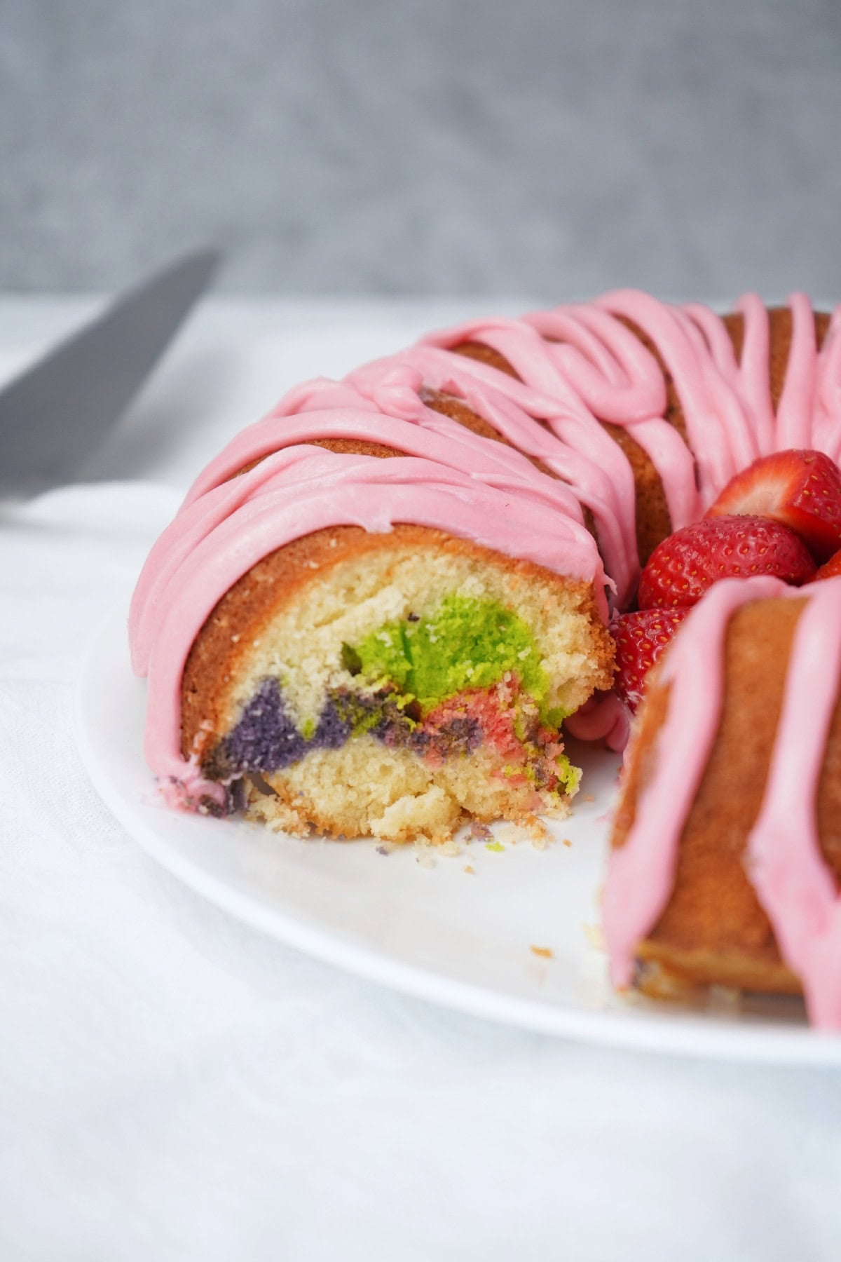 Easter bundt cake slice with green and purple marble swirl inside.