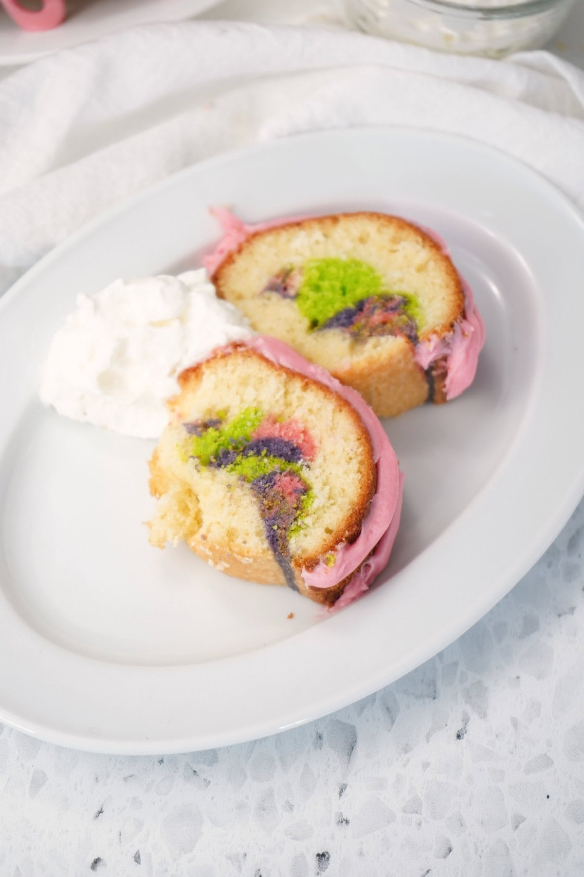 Two slices of Easter bundt cake served with whipped cream on a plate.