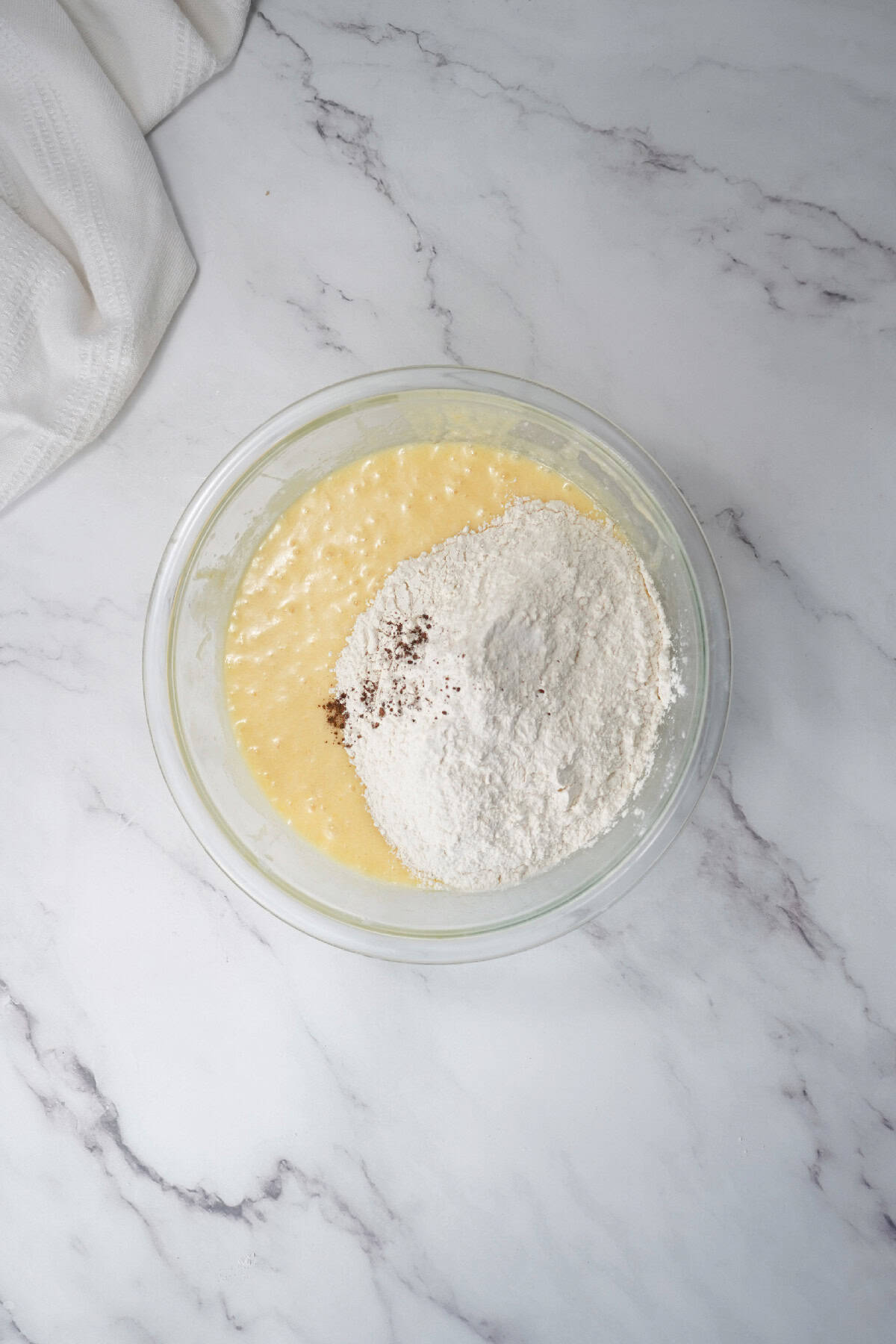 Flour and spices added to the wet ingredients for Easter bundt cake batter.