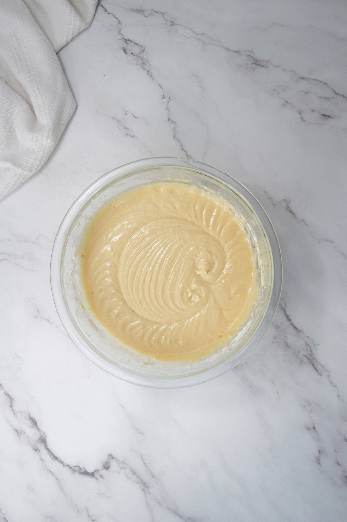 Bundt cake batter mixed until smooth and creamy in a glass bowl.