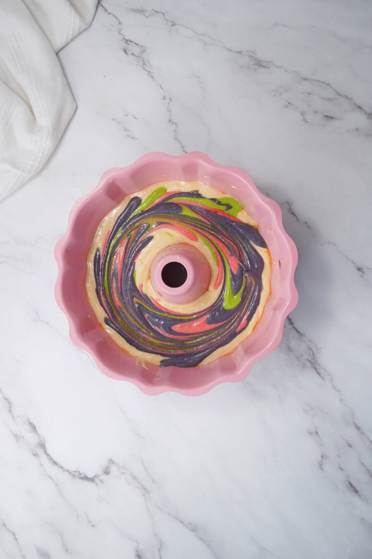 Marbled Easter bundt cake batter swirled gently inside the bundt pan.