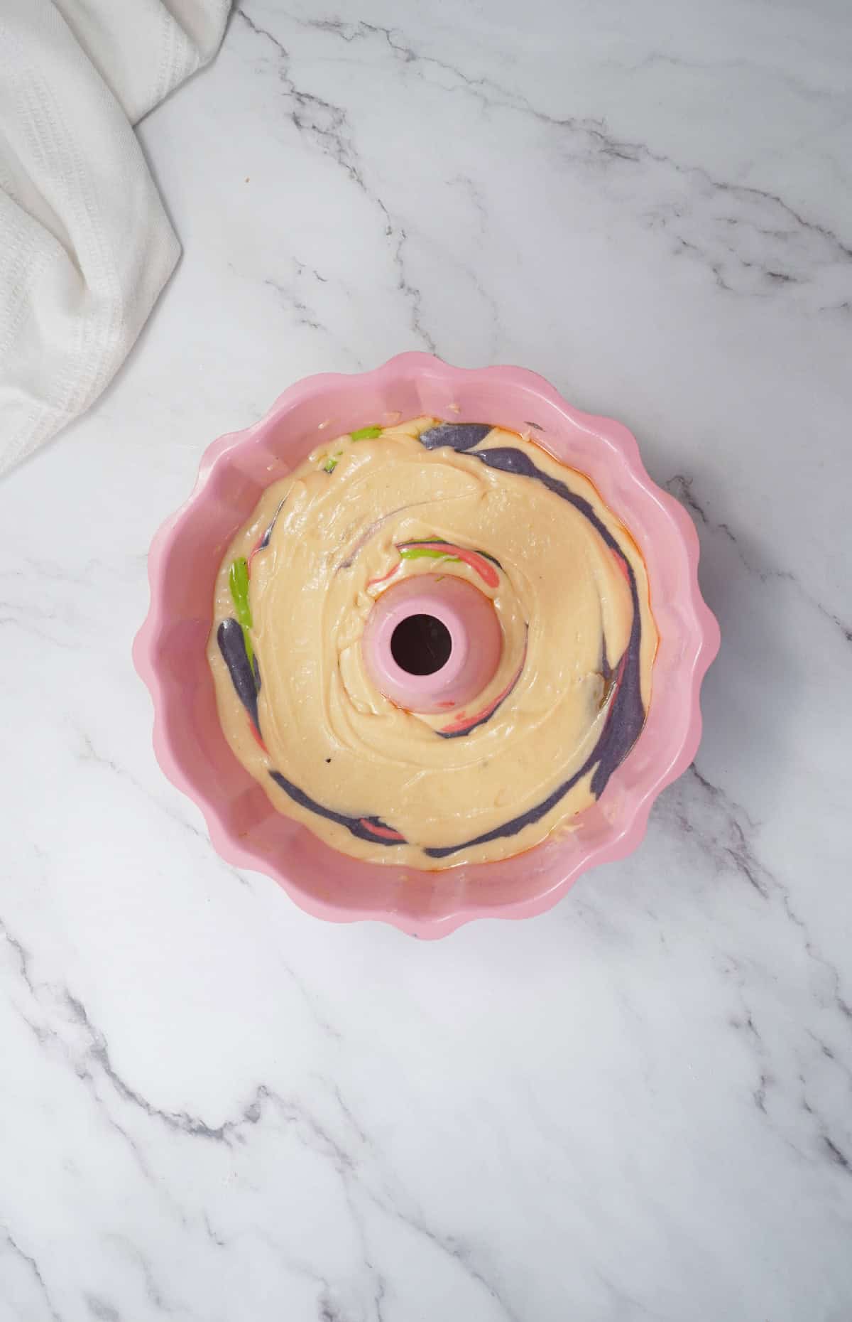 Bundt pan filled with swirled cake batter ready for baking.